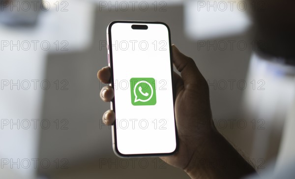 Man holding a cellphone with WhatsApp on the screen.Dhaka, Bangladesh- 09 September 2024.