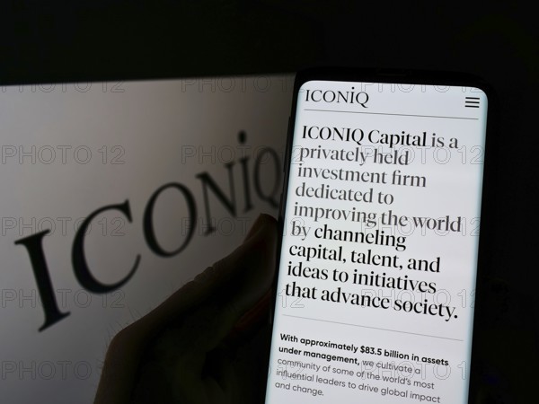 Stuttgart, Germany, 01-23-2022: Person holding smartphone with webpage of US investment company ICONIQ Capital LLC on screen in front of logo. Focus on center of phone display, Europe