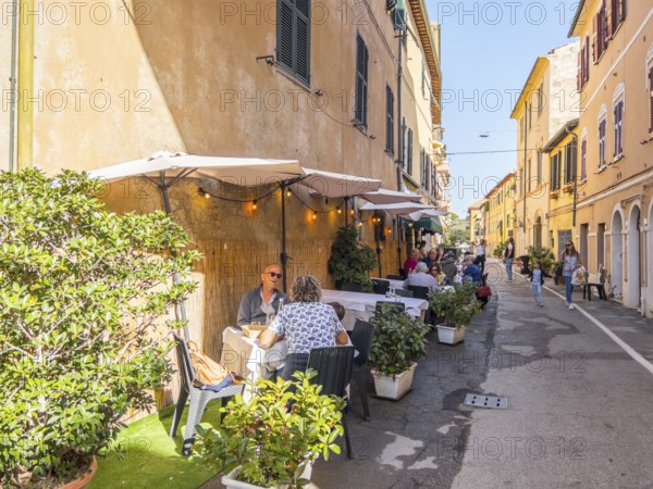 Guests at the tables in front of the restaurants in Via Roma, Orbetello, Tuscany