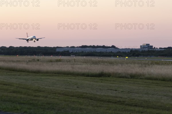 Passenger aircraft Airbus A320-214 of Austrian Airlines at dusk during landing at Hamburg Airport, Hamburg, Germany, Europe