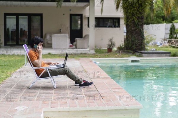 Latin man working on his laptop in the pool
