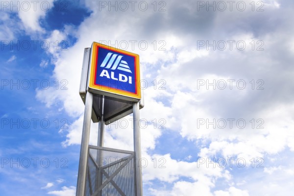Hockenheim, Germany - June 08, 2022: Commercial sign of ALDI Store against a blue sky. ALDI is a large discount supermarket chain in Germany. It specializes in lower priced products