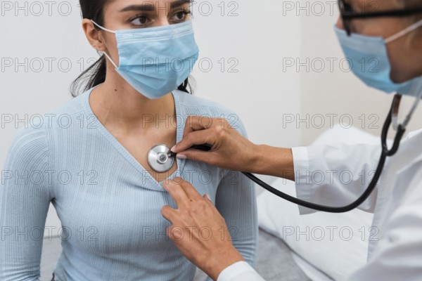 Woman checking patient with stethoscope