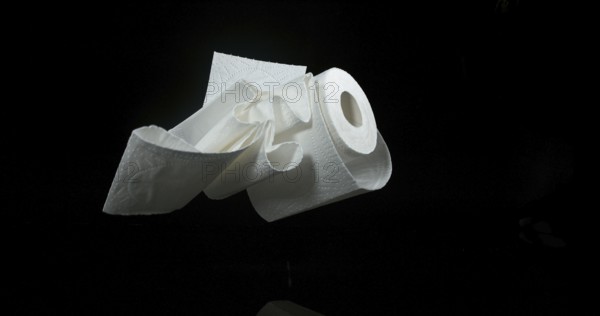 Roll of Toilet Paper Falling on Black Background
