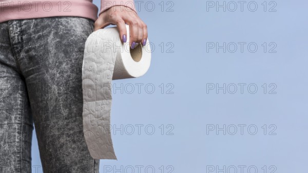 Front view person holding toilet paper roll with copy space