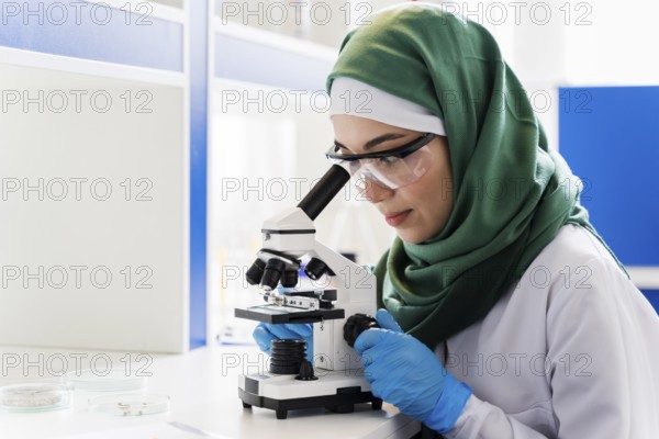 Side view female scientist with hijab microscope