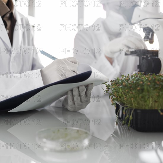Researchers with clipboard biotechnology laboratory