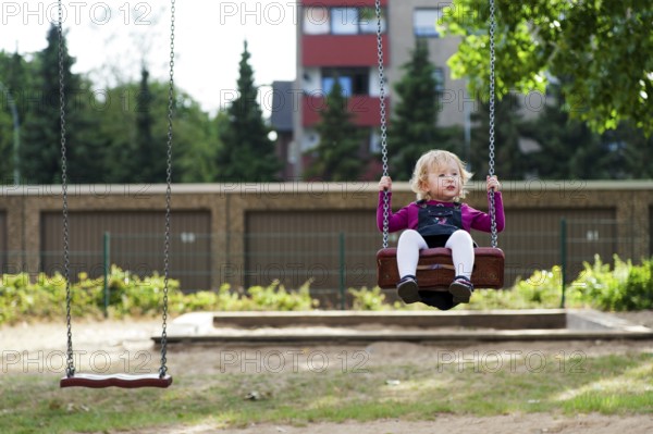 Little girl sitting on a swing