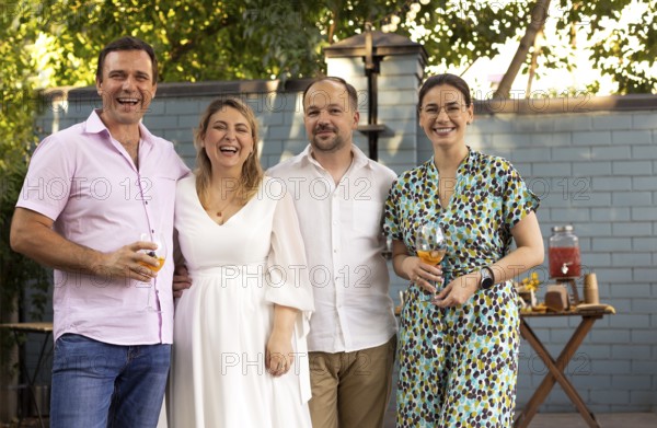 Group of beautiful happy people communicating and smiling while spending time on weding outdoors party. Happiness, love, celebration and friendship concept