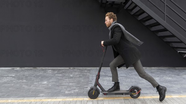 Handsome male riding electric scooter