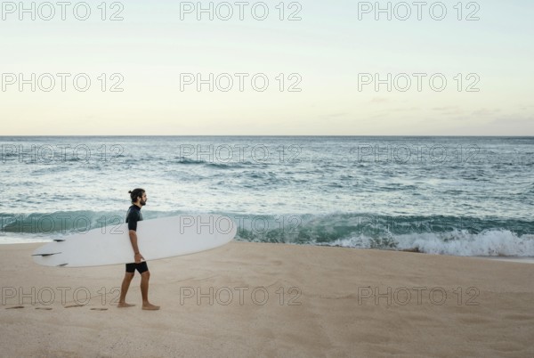 Man holding his surfing board ocean