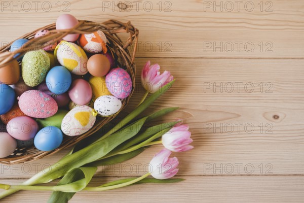 Tulips near basket with easter eggs