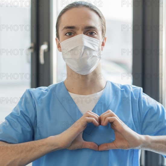 Nurse male with medical mask showing heart shape