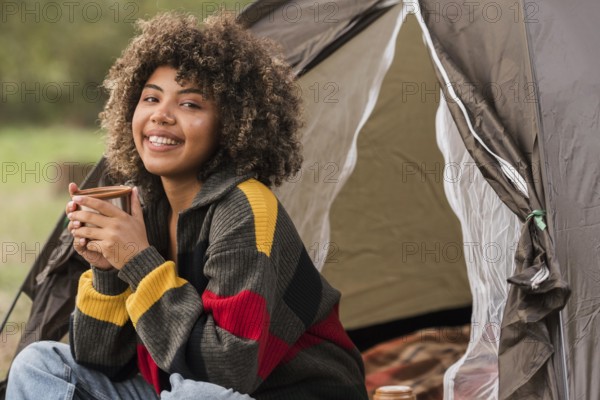 Smiley woman camping outdoors with tent