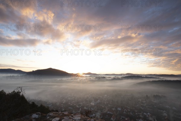 Mystical sunrise at the Wachtfelsen. Fascinating landscape shot between fog and clouds near Wernersberg, Pfälzerwald, Germany, Europe