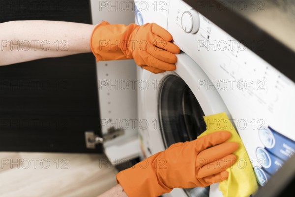High angle woman cleaning washing machine. High resolution photo