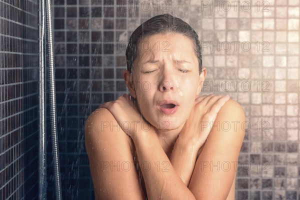 Close up Bare Young Woman Reacting While Taking Cold Shower with Arms Crossing Over her Chest and Eyes Closed
