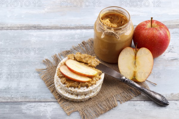 Breakfast with rice cakes, peanut butter and apple on old wooden background
