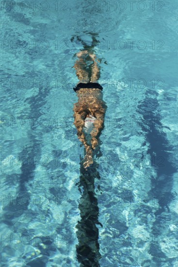 high angle male swimmer swimming water pool. High resolution photo