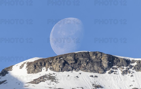 Crescent moon rises over mountain