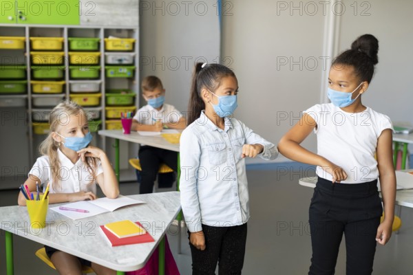Kids elbow bumping classroom
