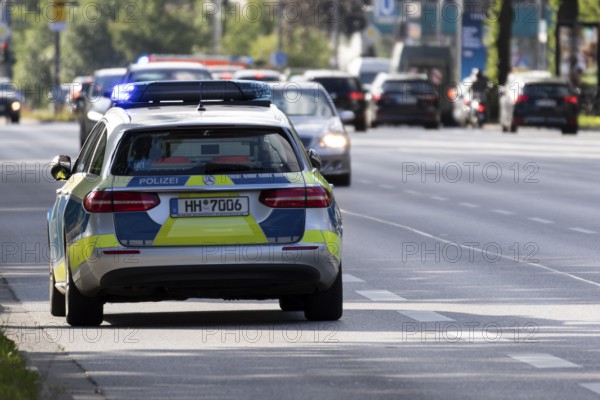 Police car in action with blue lights parked on a main road in Hamburg, Germany, Europe