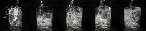 Water being poured into Glass against Black Background