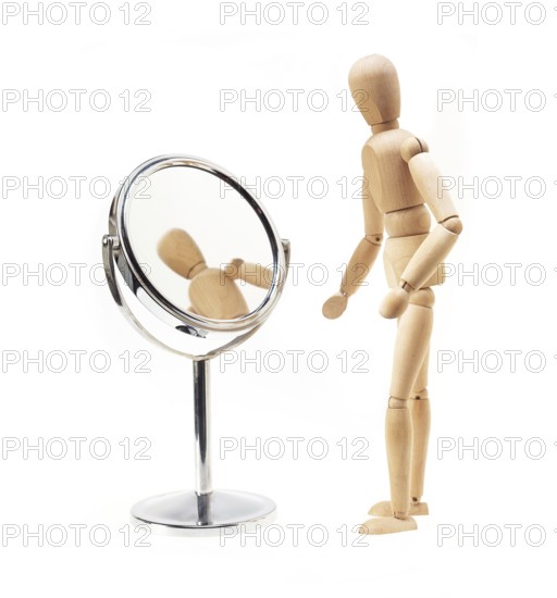 Narcissist wood mannekin looking at mirror over white