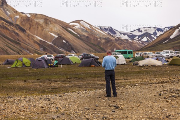 LANDMANNALAUGAR, ICELAND, JULY 09: man in a blue shirt stands at a camping site on July 09, 2013 in Landmannalaugar, Iceland, Europe