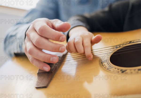 Low angle teacher child holding guitar