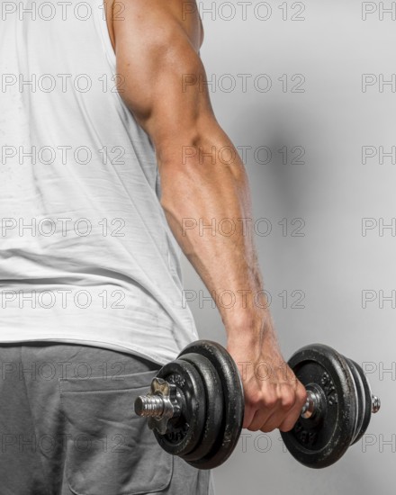 Back view very fit man holding weight