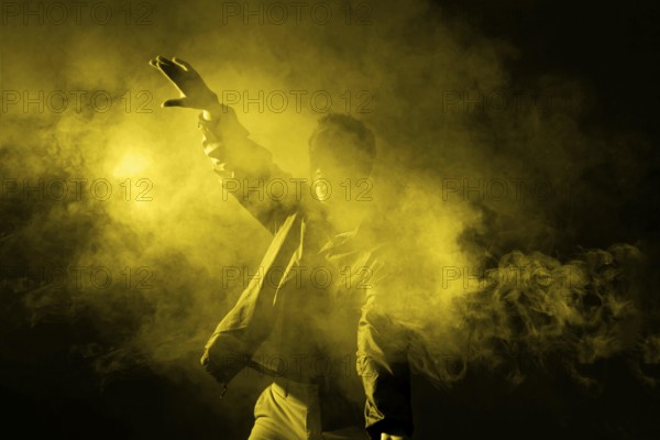 Man dancing smoke with illuminating light