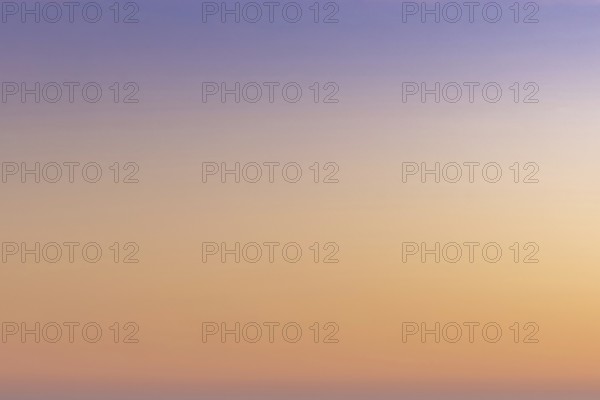 A gradient sunset sky background from orange and red to lilac and blue