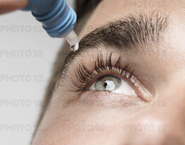 handsome man using eye drops close up