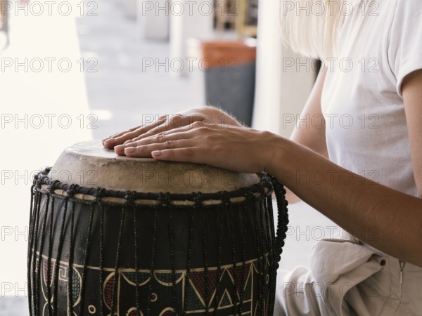 Young person playing latin percussion instrument