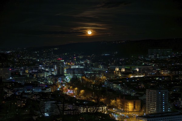 Cityscape at night in the light of the bright moon with glowing buildings and dark sky, Elberfeld, Wuppertal, Bergisches Land, North Rhine-Westphalia