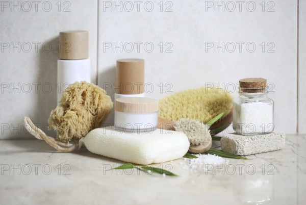 Face cream, serum, lotion, moisturizer and sea salt among bamboo leaves in the bath