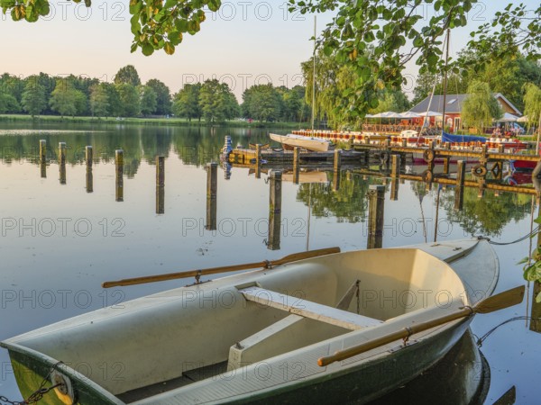 An empty boat in the foreground on a quiet lake with trees on the shore, Pröbstingsee, Borken, Münsterland, Germany, Europe