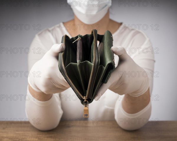 Woman with medical mask holding empty wallet