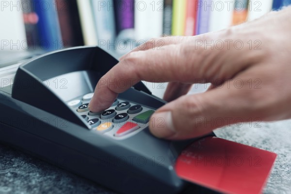 close-up of person entering PIN number on POS credit card payment terminal