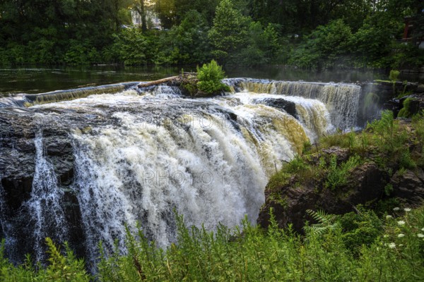 Tranquil view of cascading waterfalls with lush greenery and a calm river, Paterson Great Falls, Passaic River, Paterson, NJ, USA, North America