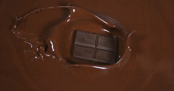 Black Chocolate tablet falling into Milk Chocolate