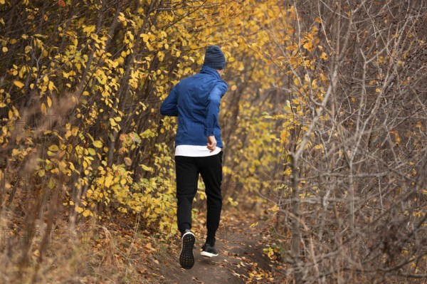 Full shot man running trail forest