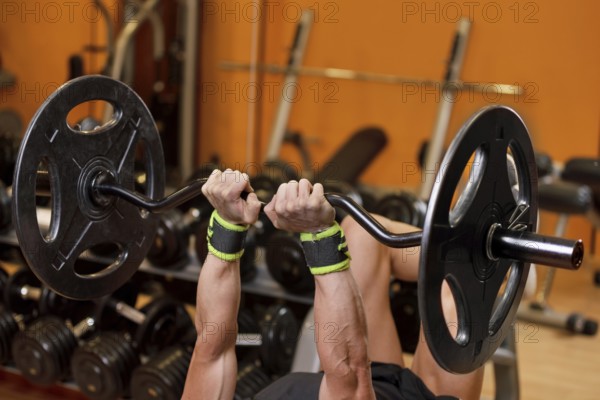Handsome young muscular man close up, doing bench french press workout with barbell in gym