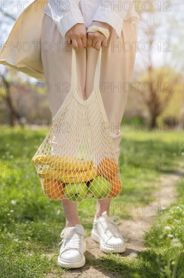 Woman holding reusable bag with food nature