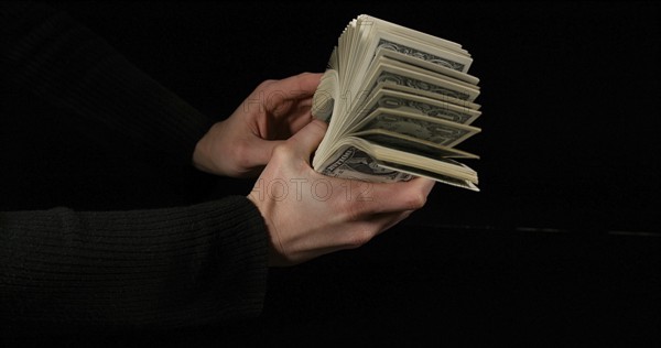 Hand of Woman and Dollar Bank Notes against Black Background