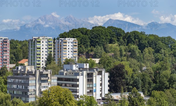 A picture of some apartments in ?kofja Loka and its surrounding vegetation and landscape
