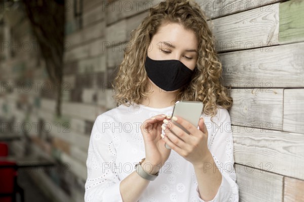 Female with mask using phone