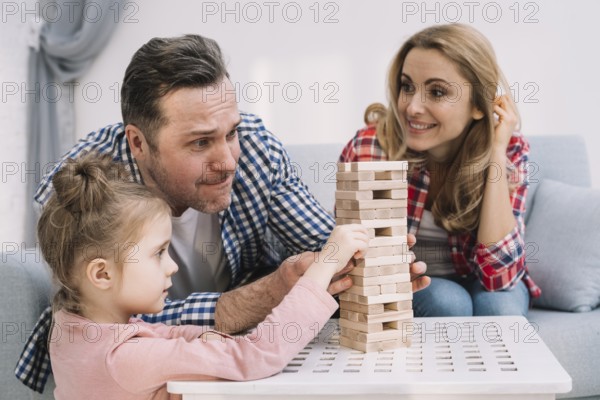 family playing with block wooden game table living room