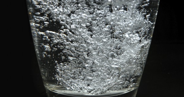 Water being poured into Glass against Black Background